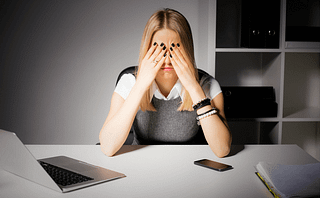 Woman sitting at desk looking stressed out